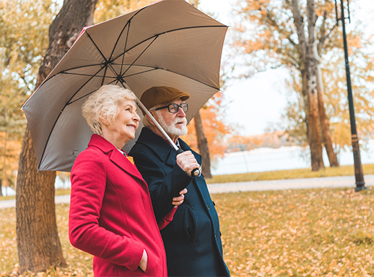 couple walking in park with umbrella during fall three principles retirement plan columbus oh