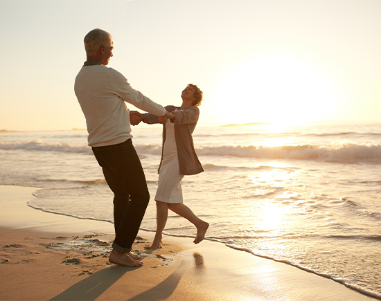 senior couple embracing with sun setting in the background actively managed money