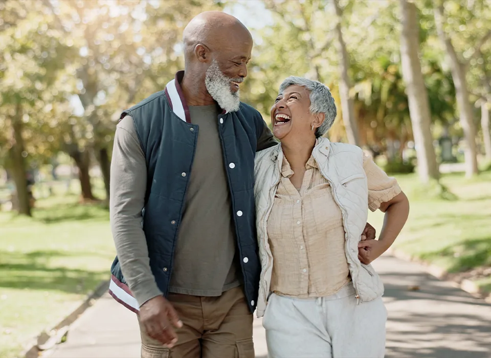 portrait of happy retirees walking outside together investment management