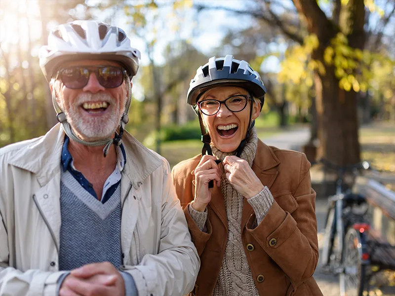 portrait of laughing seniors on a bike ride insurance products