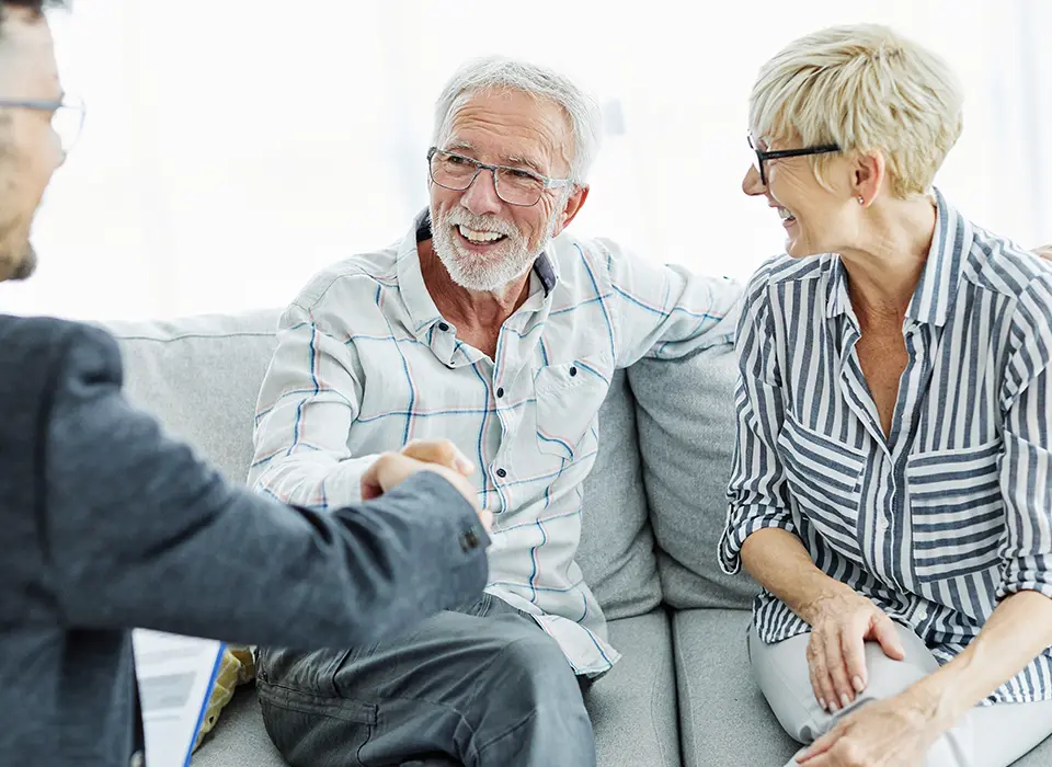 retirees shaking hands with financial advisor meeting to discuss legacy planning